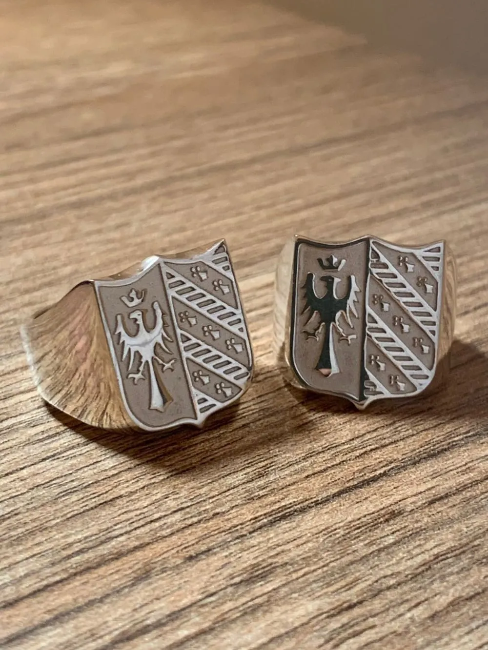 Dos anillos sello con el escudo del águila, terminados, sobre una mesa de madera